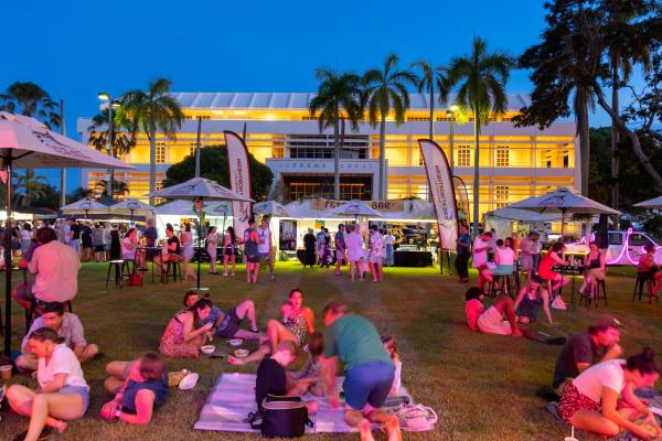 People enjoying laksa sitting on the grass at the Darwin International Laksa Festival 2021